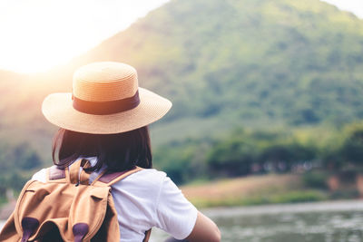 Rear view of woman wearing hat standing outdoors