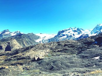 Scenic view of snowcapped mountains against clear blue sky