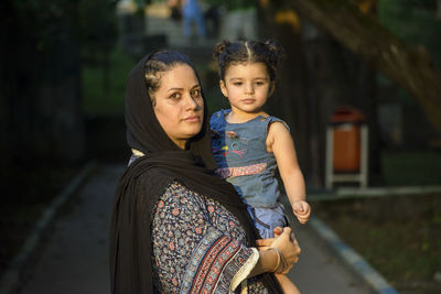 Young mother with her two years old girl in her hug , muslim family at outdoor area