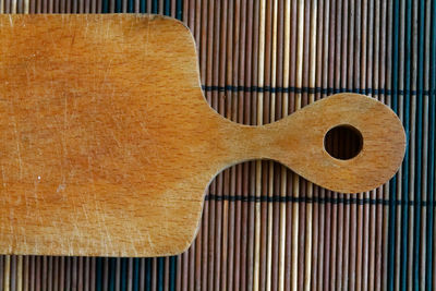 Close-up of wooden cutting board on place mat