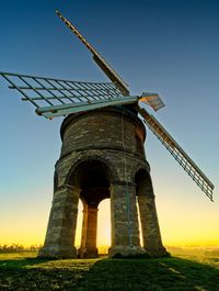 Low angle view of traditional windmill against clear sky at sunrise 