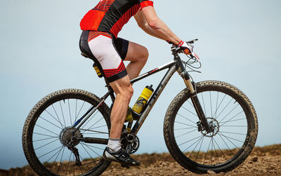 Close-up male athlete mountain biker in background sky