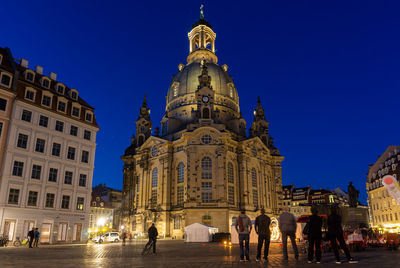Group of people in front of buildings at night