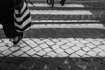 Low section of woman standing on zebra crossing