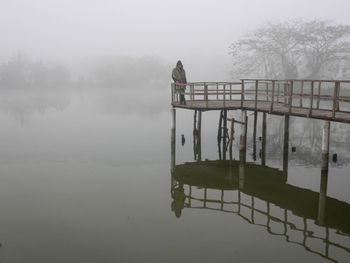 Gazebo on lake against sky