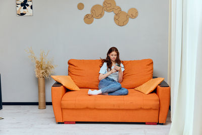 Portrait of woman sitting on sofa at home