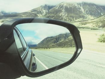 Reflection of road on side-view mirror of car