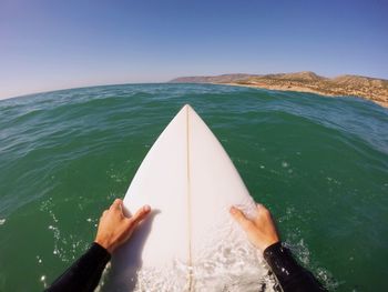 Cropped image of man surfboarding on sea