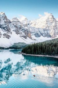 Scenic view of lake by snowcapped mountains against sky