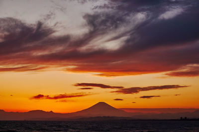 Scenic view of dramatic sky over sea during sunset