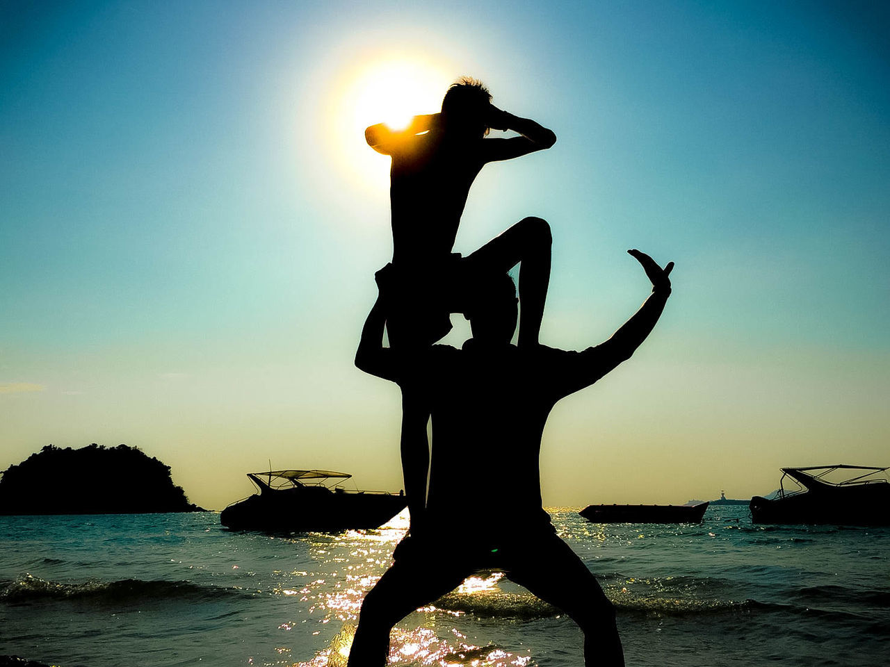 water, sky, sea, sunset, silhouette, nature, lifestyles, beauty in nature, real people, leisure activity, beach, sun, land, one person, outdoors, scenics - nature, representation, human representation, sunlight, human arm, arms raised