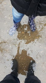 Low section of man standing on puddle