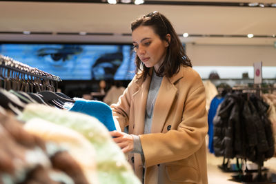 Portrait of young woman standing in store