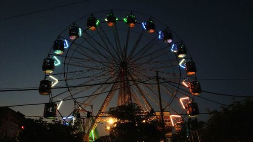 Low angle view of illuminated ferris wheel against sky at night