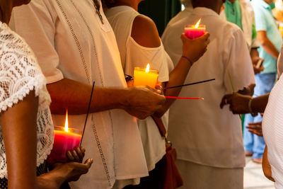 Catholic faithful holding lit candles inside the campo santo church in the city of salvador, bahia.