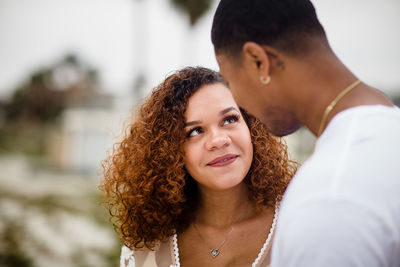 Young black woman smiling at husband on beach