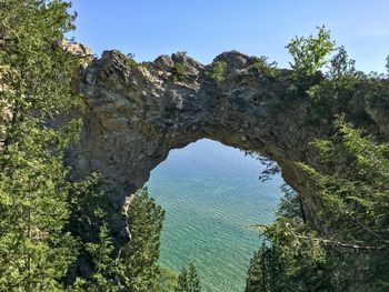 Rock formation amidst trees against sky