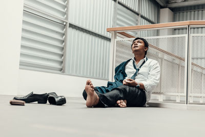 Full length of young man sitting on floor