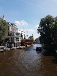 Bridge over river amidst buildings against sky