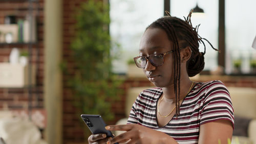 Young woman using mobile phone in cafe