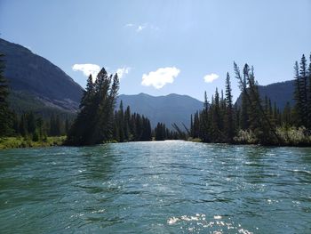 Scenic view of lake by mountains against sky