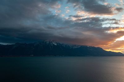 Scenic view of sea and mountains against sky during sunset