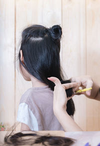 Cropped hands of hairdresser cutting hair at salon