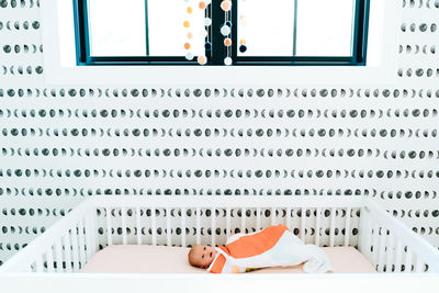 Wide angle view of a newborn baby girl lying down in a modern nursery