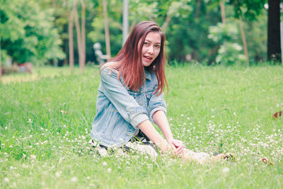 Portrait of young woman sitting on grass