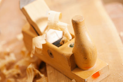 Used wood planer in the workshop of a carpenter with shavings of wood, standing on a workbench