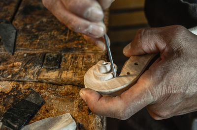 Violin maker luthier hand working a new violin scroll