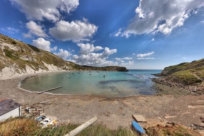 Scenic view of beach against cloudy sky