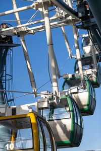 Closeup of colorful cabins of giant ferris wheel in amusement park against blue sky