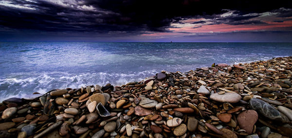 Surface level of pebbles on beach against sky