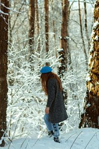 Full length of woman in snow covered forest