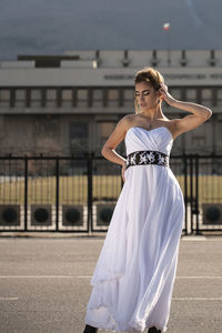 Portrait of woman standing against wall in city