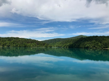 Scenic view of lake by trees against sky