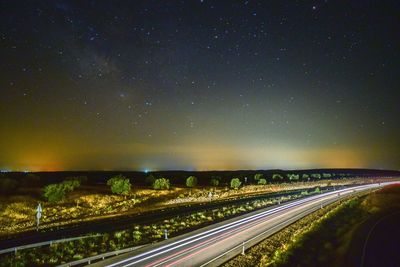 Aerial view of illuminated road against sky at night