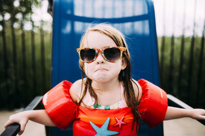 Portrait of girl in sunglasses sitting on lounge chair