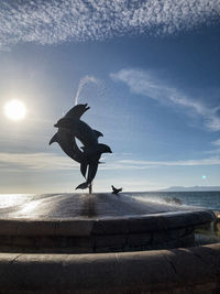 View of birds flying over sea against sky