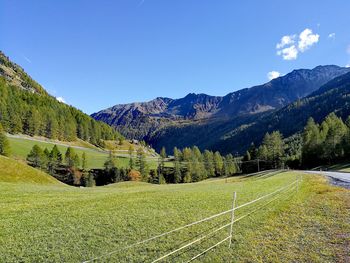 Scenic view of landscape and mountains against blue sky