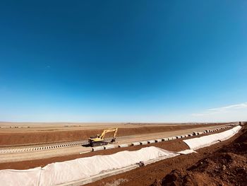 Scenic view of desert against clear blue sky