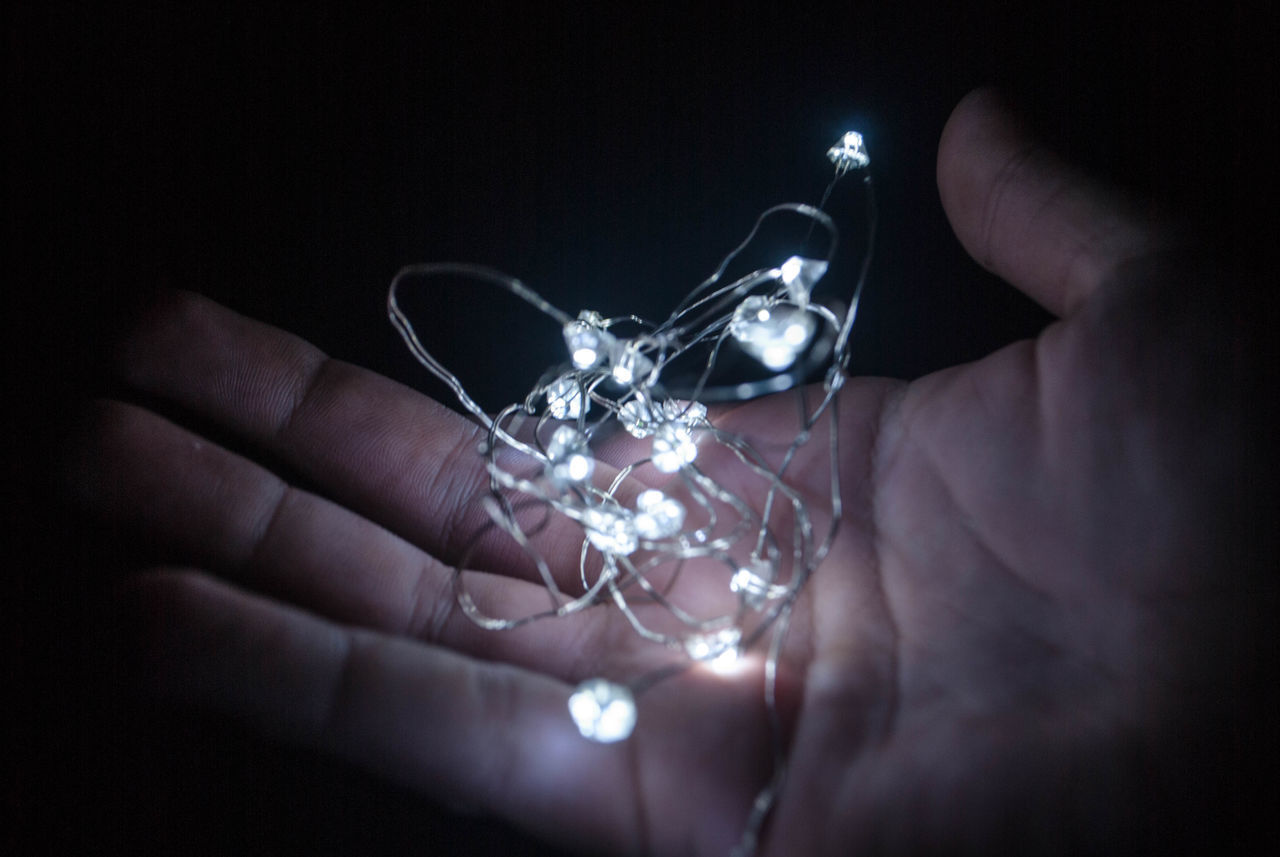 CROPPED IMAGE OF PERSON HOLDING ILLUMINATED ELECTRIC LAMP