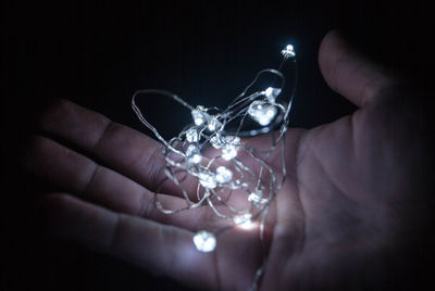 Close-up of hand holding illuminated lighting equipment