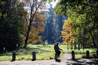 Rear view of woman walking on footpath in park