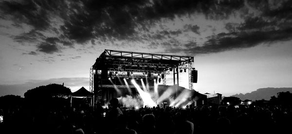 Group of silhouette people in traditional windmill against sky