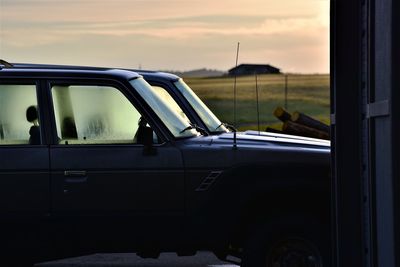 Car on road against sky seen through window