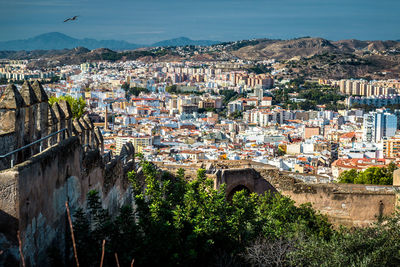 Scenic view of city by mountains against sky