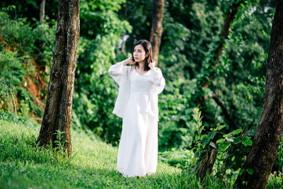 Woman standing against trees at park