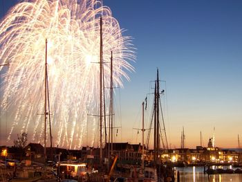 Sailboats in harbor against sky at night